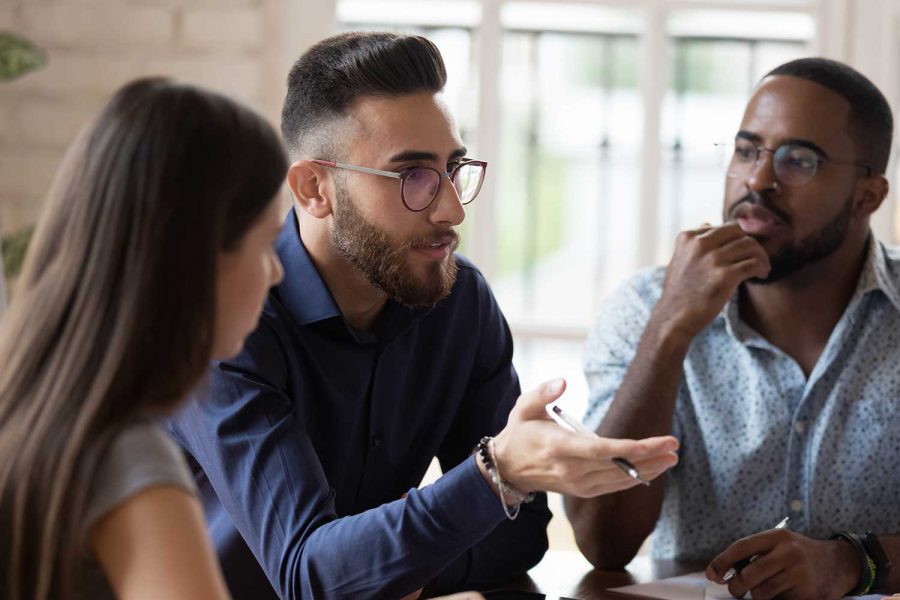 a man talking to his colleagues during a meeting